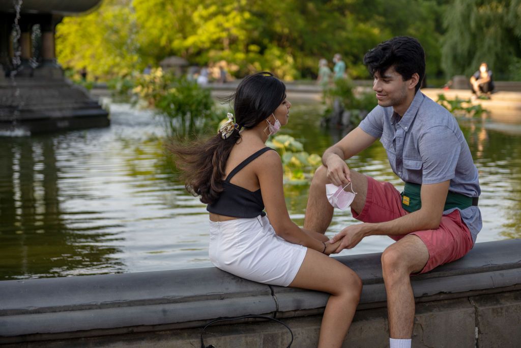 NEW YORK, NEW YORK - JULY 12: A man holds his mask in one hand while smiling at a girl at the Bethesda Fountain in Central Park as the city moves into Phase 3 of re-opening following restrictions imposed to curb the coronavirus pandemic on July 12, 2020 in New York City. Phase 3 permits the reopening of nail and tanning salons, tattoo parlors, spas and massages, dog runs and numerous other outdoor activities. Phase 3 is the third of four-phased stages designated by the state. (Photo by Alexi Rosenfeld/Getty