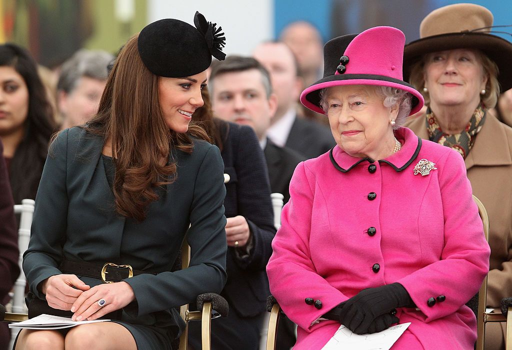 LEICESTER, ENGLAND - MARCH 08: Queen Elizabeth II (R) and Catherine, Duchess of Cambridge (L) watch a fashion show at De Montfort University on March 8, 2012 in Leicester, England. The royal visit to Leicester marks the first date of Queen Elizabeth II's Diamond Jubilee tour of the UK between March 8 and July 25, 2012. (Photo by Oli Scarff - WPA Pool / Getty Images)