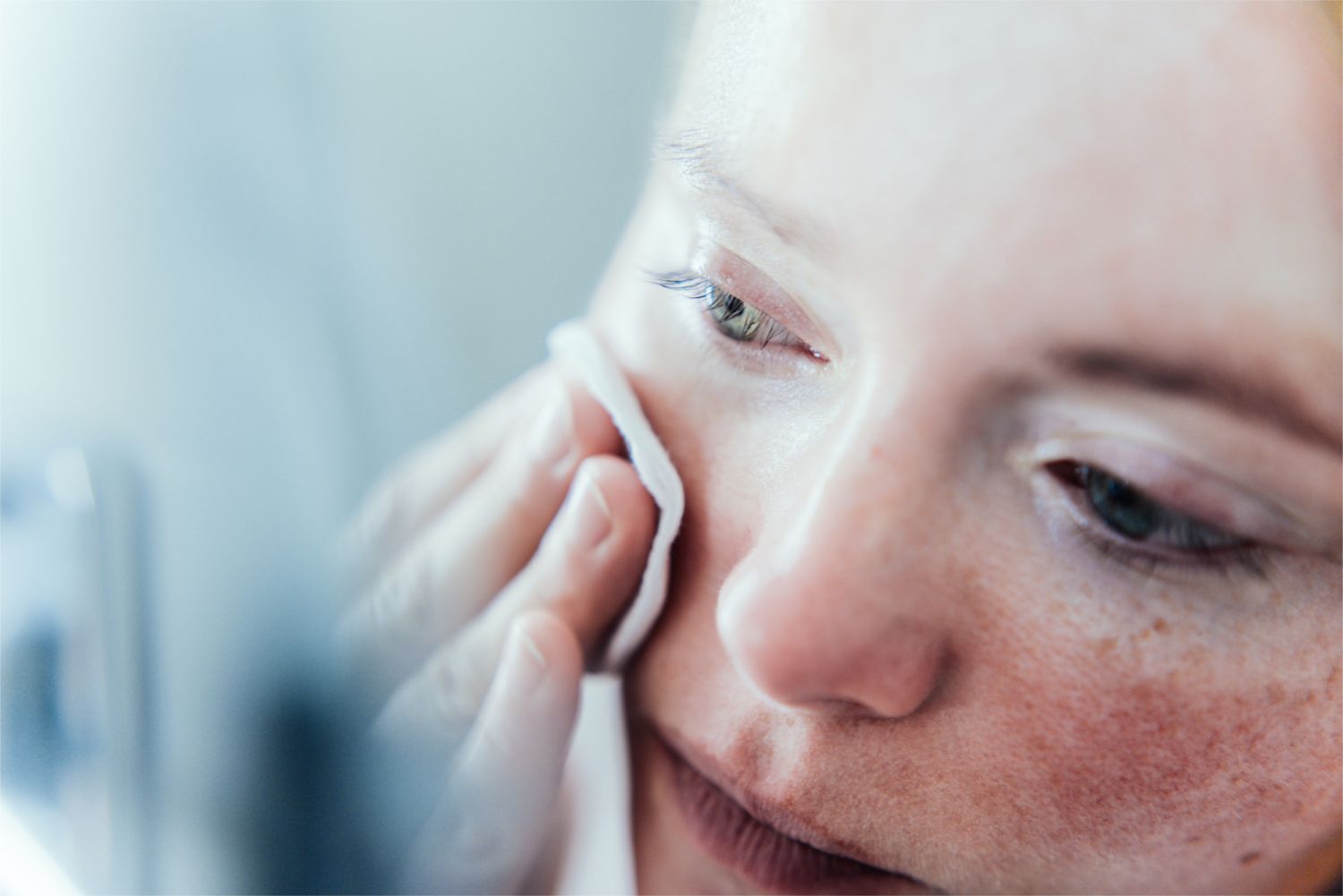 Woman removing make up in bathroom.