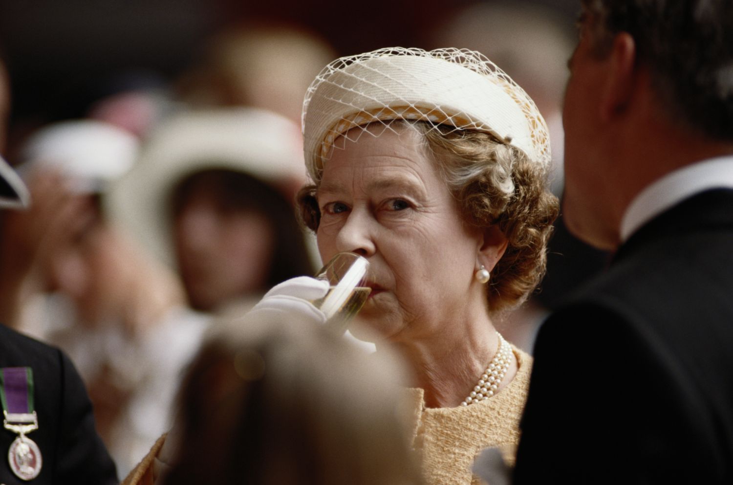 Queen Elizabeth II drinking a glass of champagne on-board HMS Invincible, following a recommissioning service in Portsmouth, Hampshire, England, Great Britain, 18 May 1989. (Photo by Tim Graham Photo Library via Getty Images)