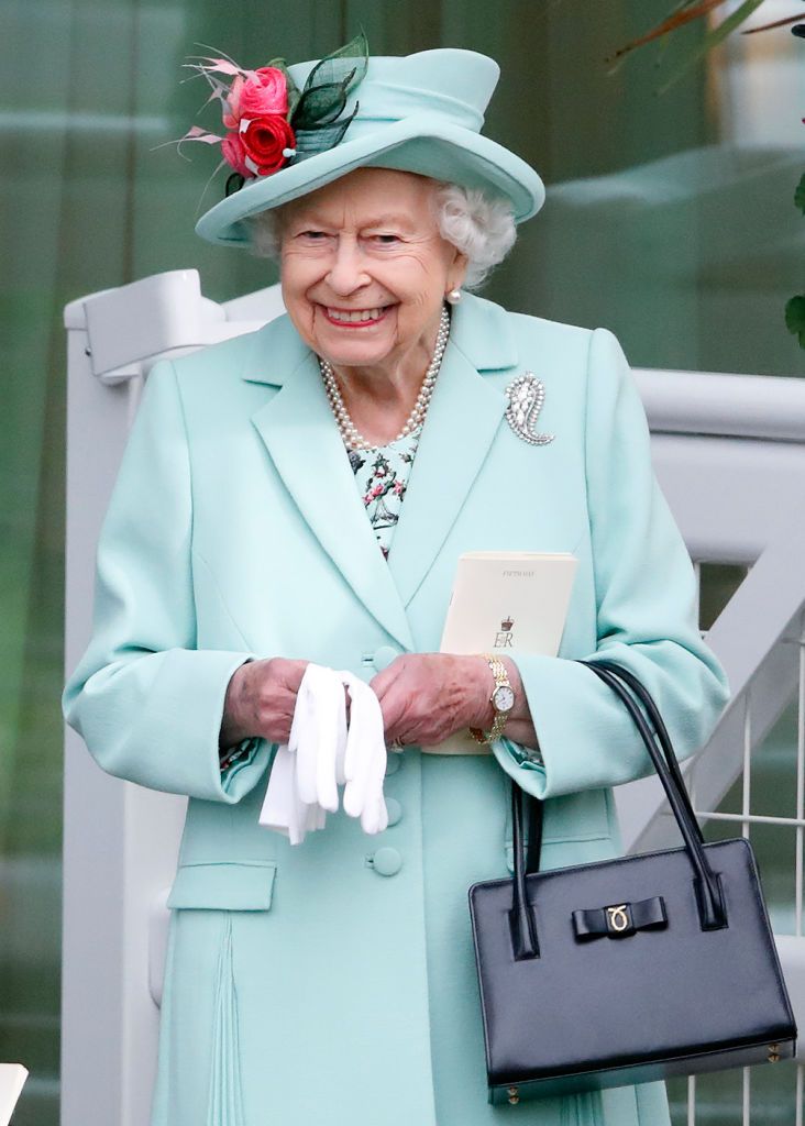 ASCOT, UNITED KINGDOM - JUNE 19: (EMBARGOED FOR PUBLICATION IN UK NEWSPAPERS UNTIL 24 HOURS AFTER CREATE DATE AND TIME) Queen Elizabeth II (wearing her Cartier diamond Palm Leaf Brooch, which belonged to Queen Elizabeth, The Queen Mother) holds a racecard as she attends day 5 of Royal Ascot at Ascot Racecourse on June 19, 2021 in Ascot, England. (Photo by Max Mumby/Indigo/Getty Images)