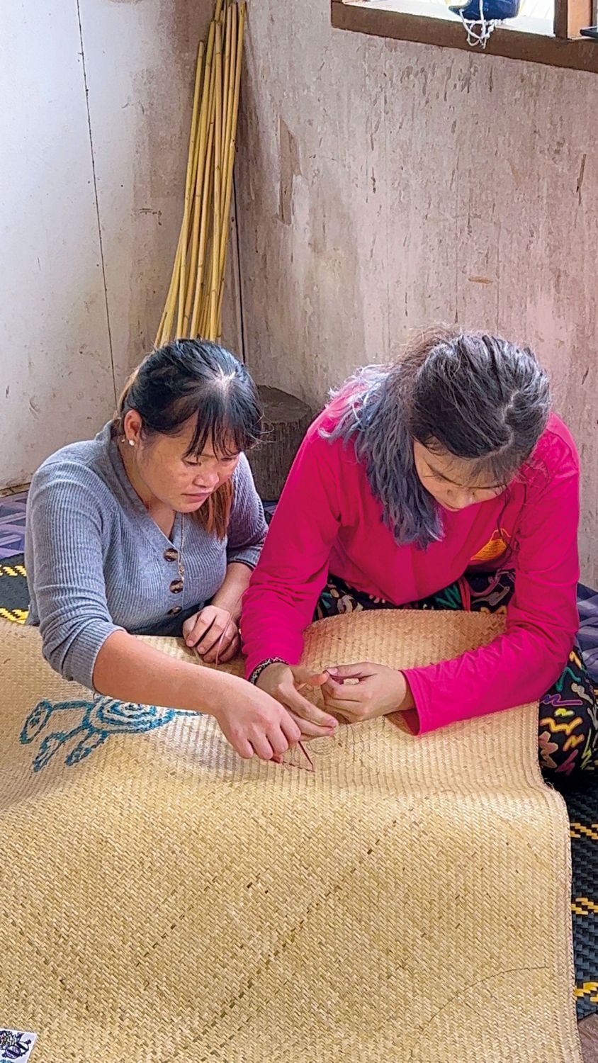 The Penan weavers discussing how to incorporate the illustrations that Maya, Looi's daughter, had done for the collection