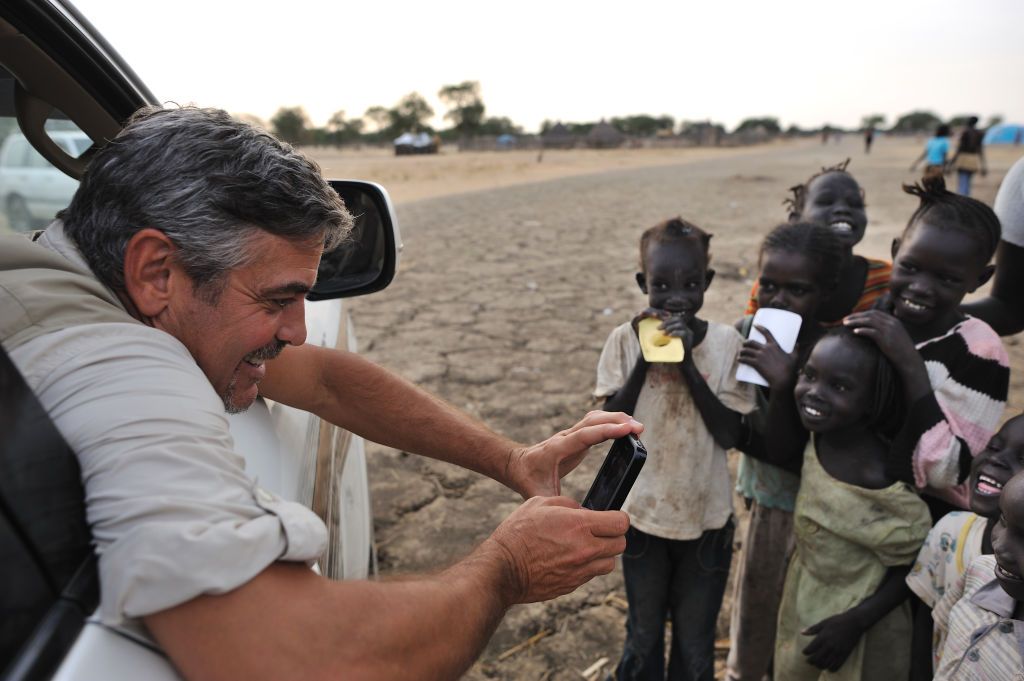 SOUTH SUDAN - JANUARY 2011: Actor George Clooney photographs children in a camp for South Sudanese, returnees from North Sudan anticipating the referendum to separate North and South Sudan, in Abyei, southern Sudan, Jan. 7, 2011. Clooney, who has been involved with Sudan for five years, directed his star power toward helping South Sudanese peacefully achieve independence from the northern government of Khartoum after two decades of civil war. (Photo by Lynsey Addario/Getty Images Reportage)