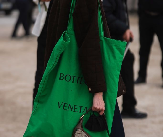 PARIS, FRANCE - MARCH 01: Model Lucy Rosiek carries an oversized green Bottega Veneta shopping tote bag at the Dior show at Jardin de Tuileries during Paris Fashion Week Fall/Winter 2022 on March 01, 2022 in Paris, France. (Photo by Jeremy Moeller/Getty Images)
