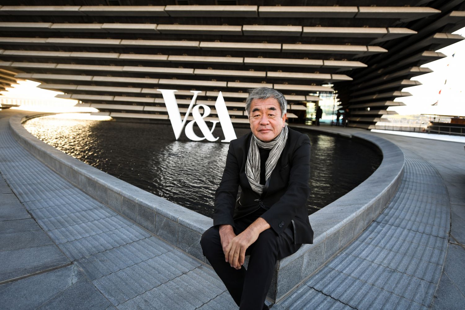 DUNDEE, SCOTLAND - SEPTEMBER 12: Japanese architect Kengo Kuma sits outside the new V&A museum of Design during a preview on September 12, 2018 in Dundee, Scotland. Dundee's landmark V&A Museum of Design has been more than ten years in the planning with the £80m building set to open to the public on Saturday, September 15. (Photo by Jeff J Mitchell/Getty Images)