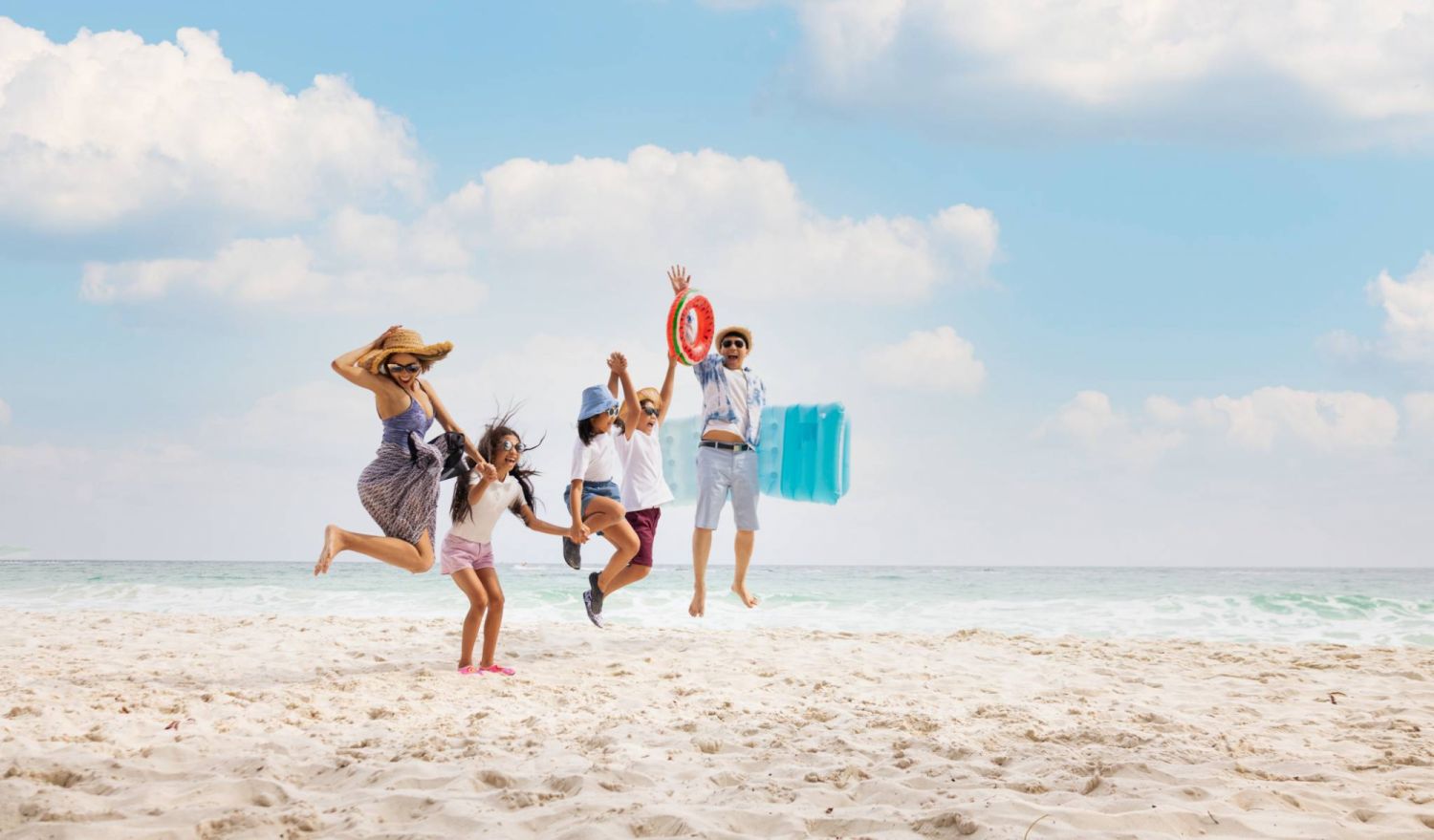Happy asian family jumping together on the beach in holiday. Silhouette of the family holding hands enjoying the sunset on the beach.Happy family travel and vacations concept.