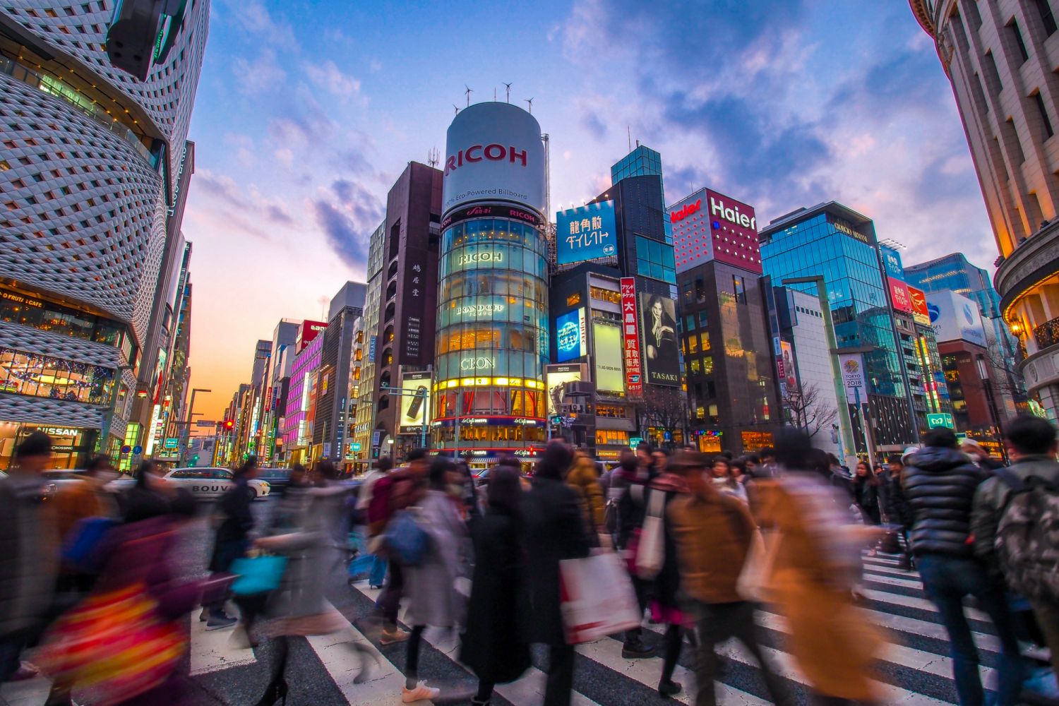 Chuo Ward, Tokyo, Japan - February 23, 2018; Top luxury shopping streets with multi colored neon signs. Ginza avenues are lined with shops of expensive brands and restaurants in the heart of Tokyo. It is half past five p.m. on Friday. People flock to Ginza for shopping, dinner and drinking with their friends. Ginza became synonymous with major shopping districts in Japan.
