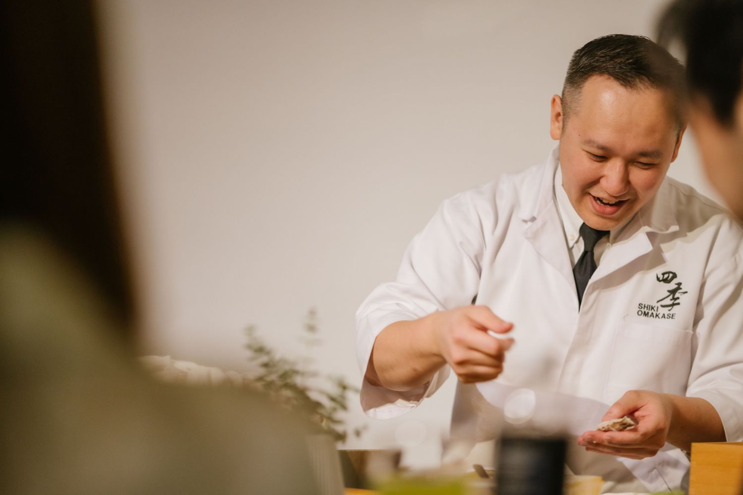 Ronii Lee prepping his mantis shrimp while interacting with diners