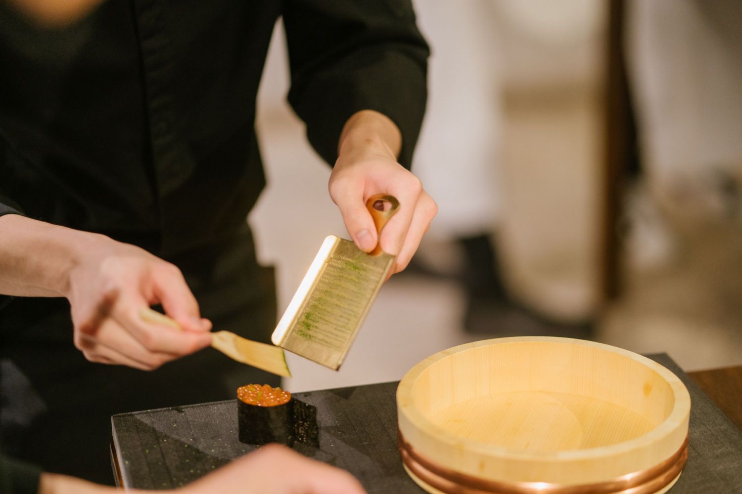 Nicholas Yap topping off his ikura sushi with some lime zest