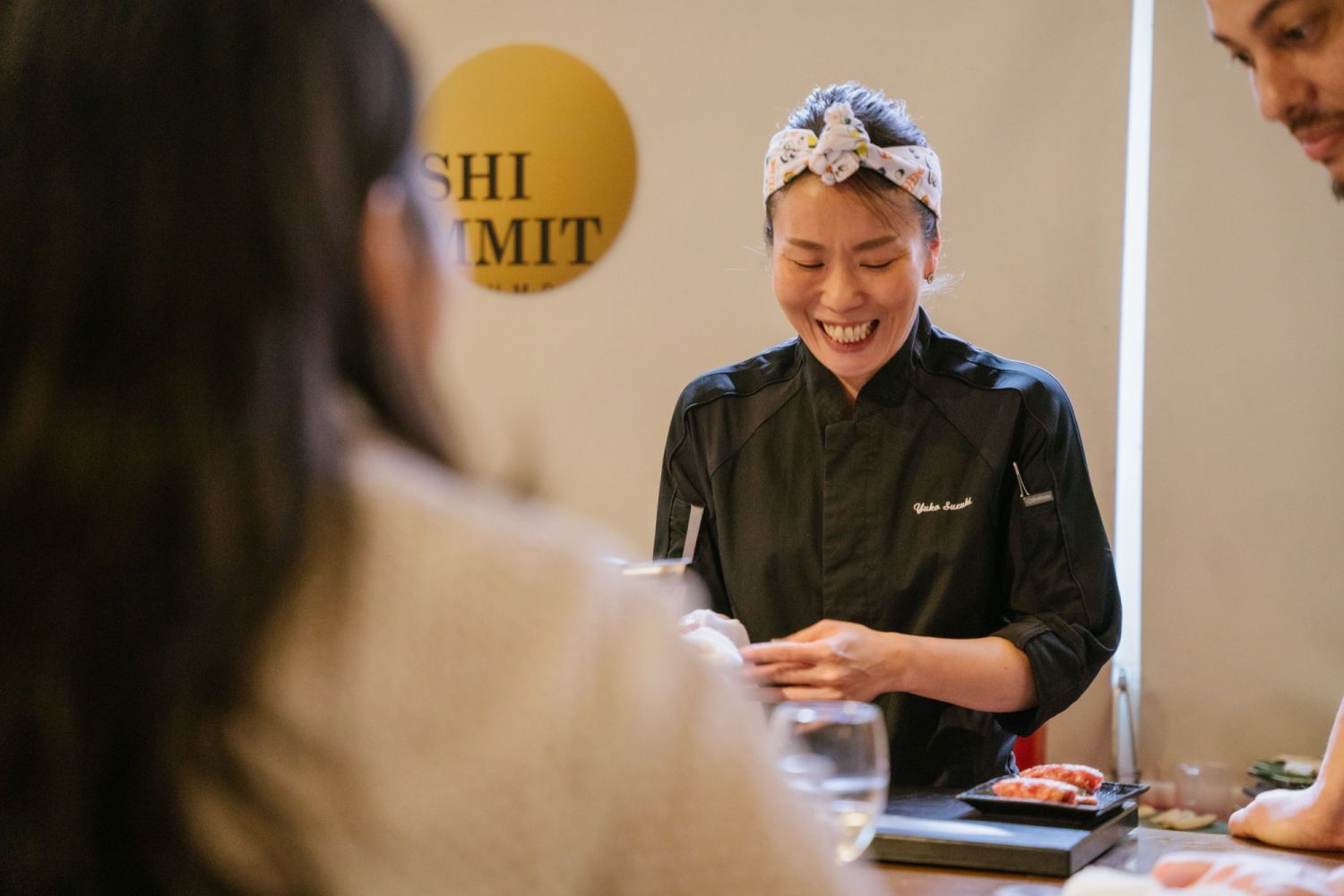 Yuko Suzuki laughing as she exchanges stories with her diners
