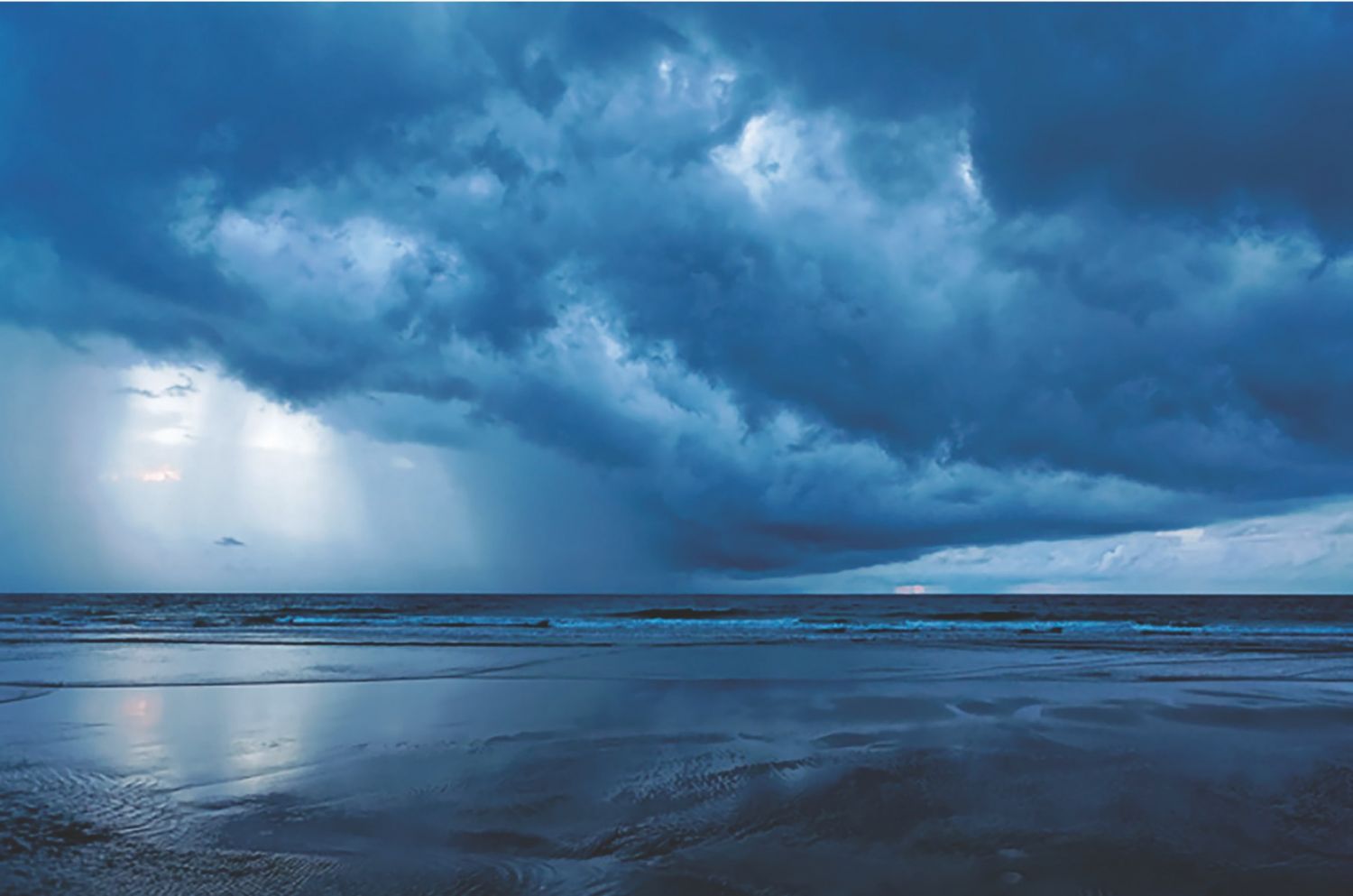 A rain squall approaches one of Puerto Princesa’s northern beaches, as seen in the book, Puerto Princesa: The Forest City