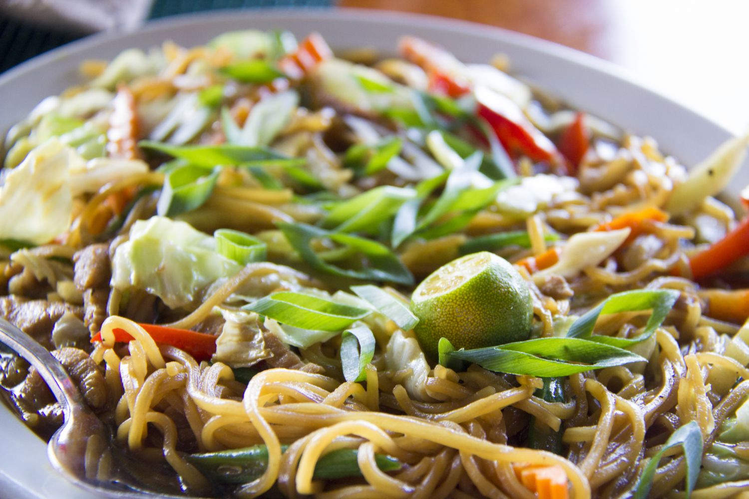 Cebu Island, Philippines - March 2017: in the Filipino language, pancit or pansit is the word for noodles. Pancit canton is one very popular and traditional variety of noodles eaten at the Philippines. On top of the meal is a calamansi fruit, a very commonly used sour fruit. As seen in a local filipino restaurant on the West Coast of Cebu Island