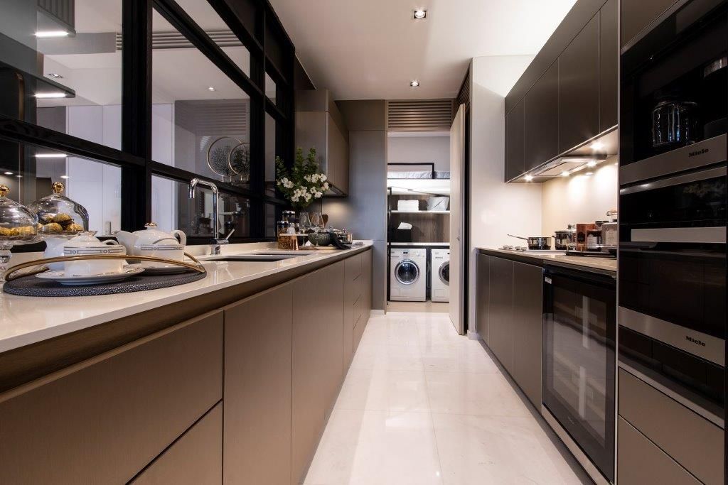 The kitchen features cabinetry in an earthy scheme and appliances from Miele