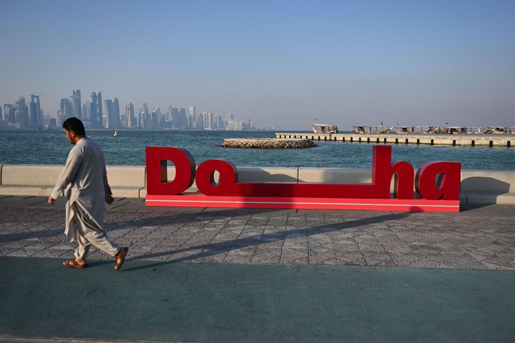 A man walks past 2022 FIFA World Cup branding on the corniche in Doha, Qatar on 8 October 2022, just weeks before the beginning of the 2022 FIFA World Cup. (Photo by Simon Holmes/NurPhoto via Getty Images)
