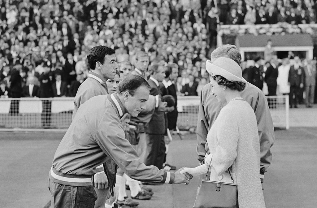 Queen Elizabeth II shaking hands with footballer George Cohen at Wembley before England's first group game of the 1966 World Cup, 11th July 1966. Gordon Banks stands next to Cohen. (Photo by Central Press/Hulton Archive/Getty Images)