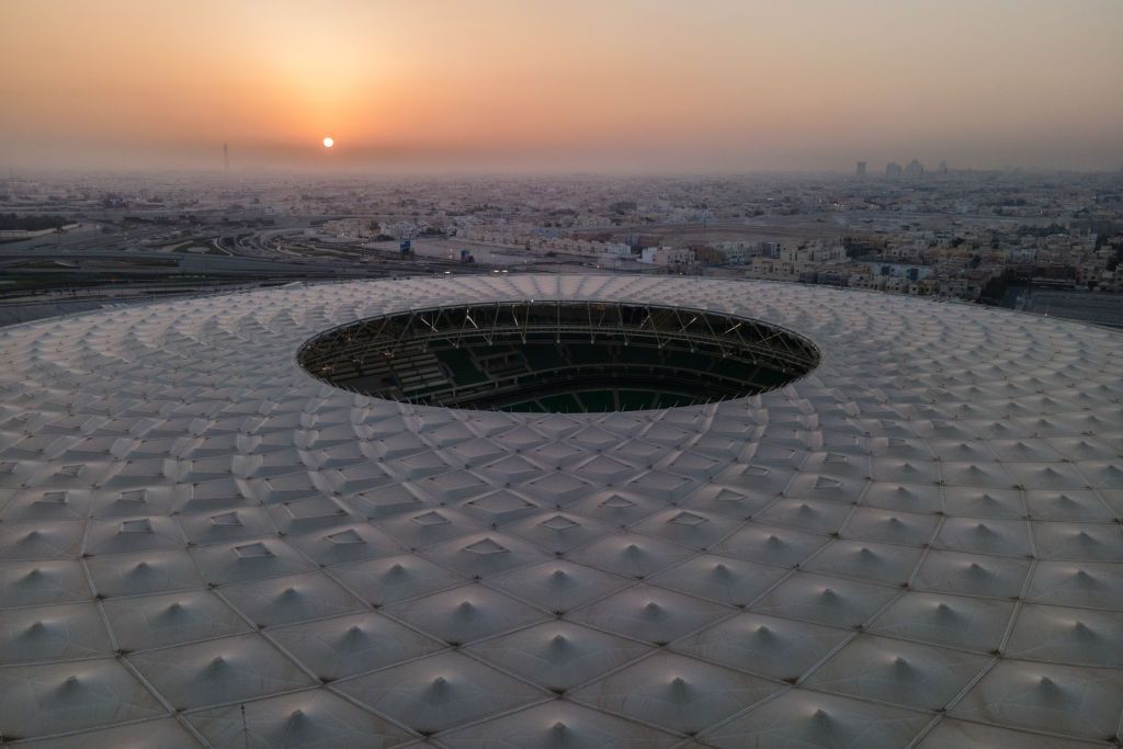DOHA, QATAR - JUNE 22: (EDITORS NOTE: This photograph was taken using a drone) An aerial view of Al Thumama stadium at sunset on June 22, 2022 in Doha, Qatar. Designed by the architect Ibrahim M. Jaidah, the stadiumâs bold, circular form reflects the gahfiya â a traditional woven cap adorned by men and boys all across the Middle East for centuries. Al Thumama stadium is a host venue of the FIFA World Cup Qatar 2022 starting in November. (Photo by David Ramos/Getty Images)