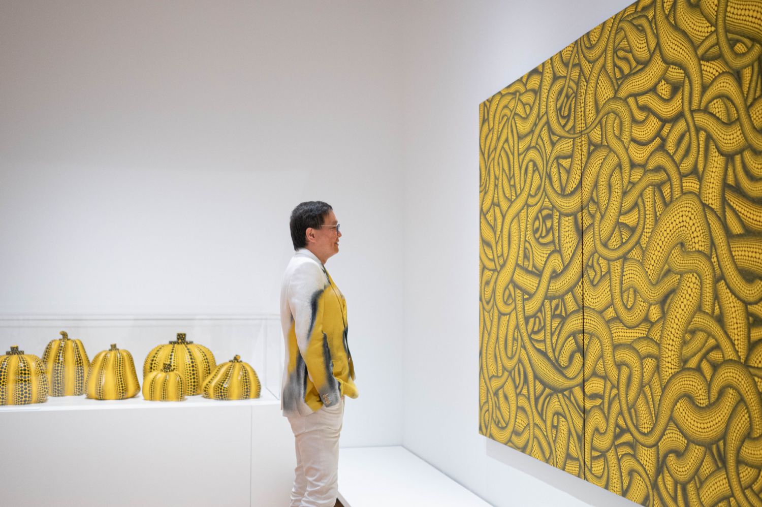 A guest in front of Kusama's Pumpkins (1998 - 2008) (Left) and Sex Obsession (1992) (Right), Photo: Kenneth Tang