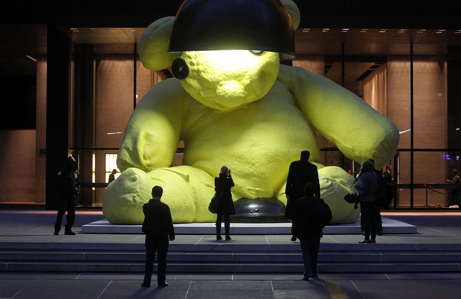 NEW YORK, NY - APRIL 08: People view the 23-foot "Unitled (LAMP/BEAR)" outdoor sculpture of a teddy bear by artist Urs Fischer April 8, 2011 in New York City. The 35,000 pound sculpture of a yellow teddy bear with a working lamp will be on display for five months in front of the Seagram Building in Manhattan. The sculpture is expected to sell for more than $10 million at ChristieÂs Post-War & Contemporary Evening Sale on May 11. (Photo by Mario Tama/Getty Images)