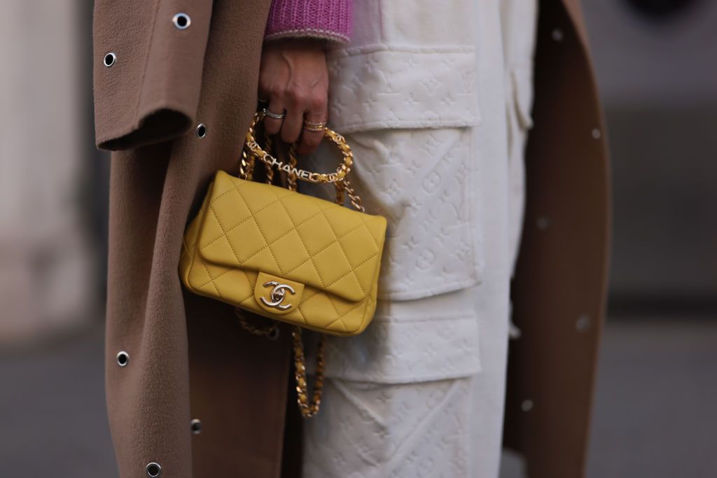 VIENNA, AUSTRIA - NOVEMBER 25: Karin Teigl is seen wearing Chanel yellow leather bag, Lala Berlin beige long coat, Miu Miu knit pink/white logo sweater and Louis Vuitton beige comfy jogging pants, on November 25, 2022 in Vienna, Austria. (Photo by Jeremy Moeller/Getty Images)