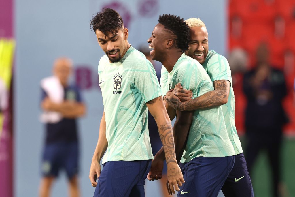 DOHA, QATAR - DECEMBER 08: Neymar (R) of Brazil jokes with team mate Vinicius Junior (C) and Lucas Paqueta (L) during a training session on match day -1 at Al Arabi SC Stadium on December 08, 2022 in Doha, Qatar. (Photo by Alexander Hassenstein/Getty Images)
