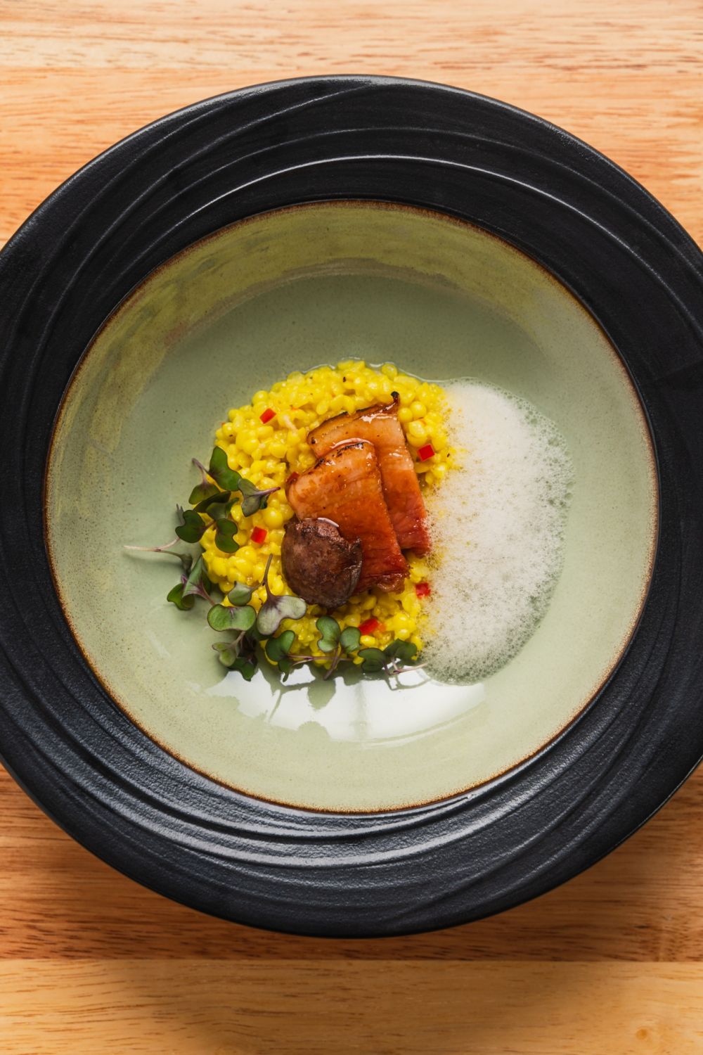 Bringhe: coconut and turmeric-infused adlai, jomemade jamon de Bulacan, seared foie gras, and clam foam