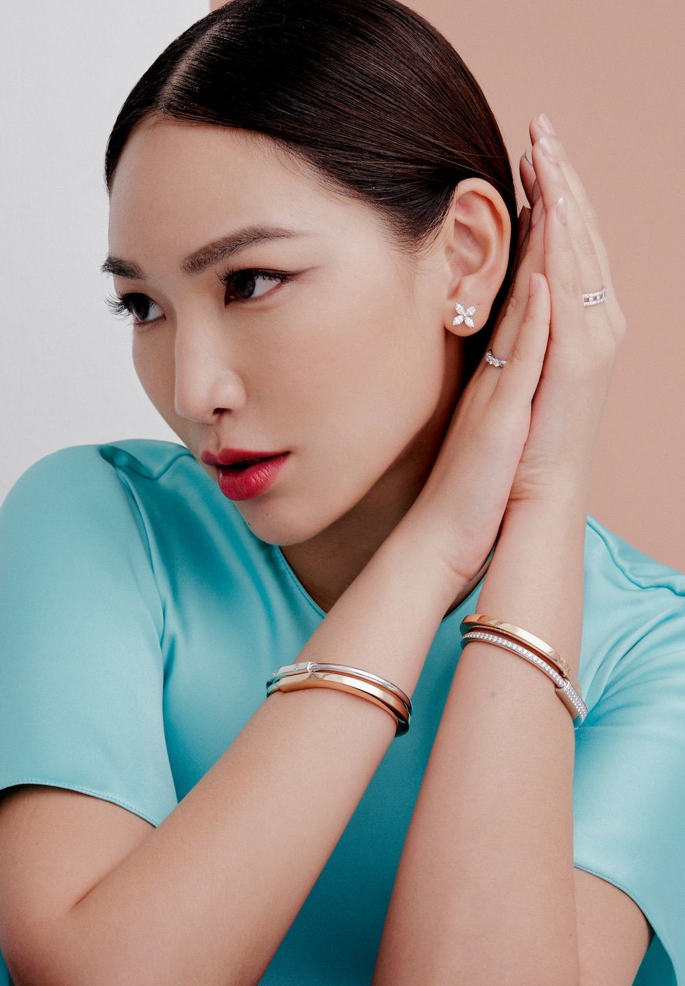 Jane Lau wears Tiffany Victoria earrings, Tiffany Lock bangles, Tiffany Embrace band ring, and Tiffany T True wide ring; Fendi dress