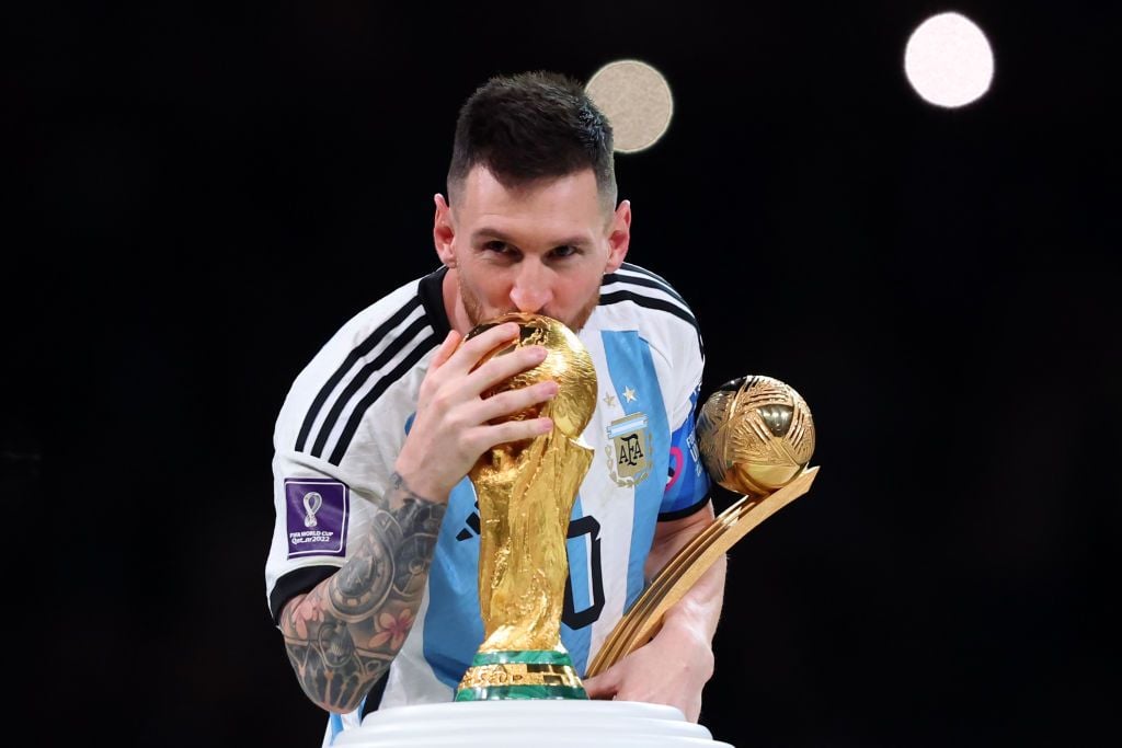 LUSAIL CITY, QATAR - DECEMBER 18: Lionel Messi of Argentina poses with his player of the tournament award and the World Cup trophy after the FIFA World Cup Qatar 2022 Final match between Argentina and France at Lusail Stadium on December 18, 2022 in Lusail City, Qatar. (Photo by Marc Atkins/Getty Images)