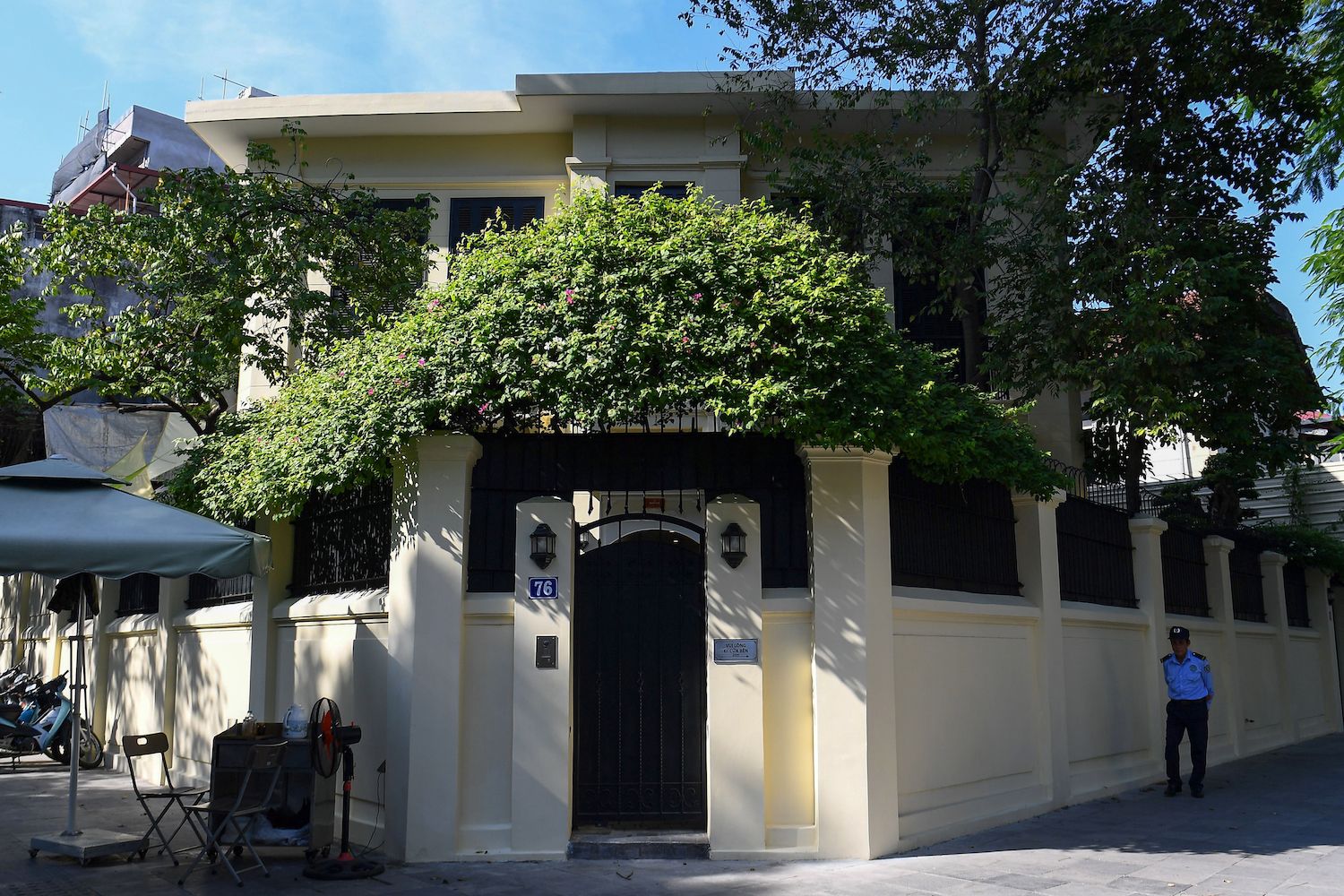 This photo taken on November 2, 2022 shows a security guard walking past an old villa in Hanoi. Most of the hundreds of French-style, century-old villas in central Hanoi have been degraded by age and humidity, and despite their protected status the future of these homes and their occupants hang in the balance, as residents struggle to afford their upkeep. (Photo by Nhac NGUYEN / AFP)
