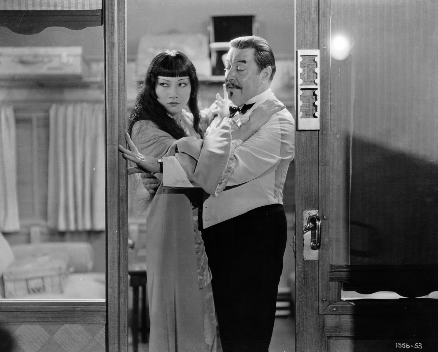 1932: Anna May Wong (1905 - 1961) and Warner Oland (1880 - 1938) steal an embrace in the doorway of a train compartment, in a scene from the film 'Shanghai Express', directed by Josef von Sternberg. (Photo via John Kobal Foundation/Getty Images)