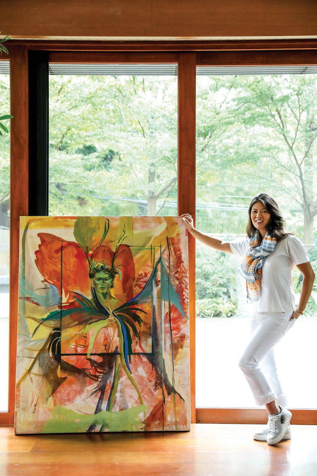 Jana Benitez next to her painting Antonio (2022) which merges her signature styles of poignant figuration and vibrant gestural abstraction