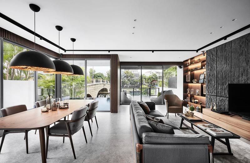The living and dining area is clad in veined, homogeneous floor tiles, paired with walnut veneer on the timber strips and black mild steel shelves (Photography: Wong Wei Liang)