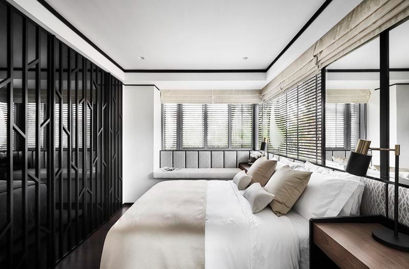The gridwork on the cabinetry creates visual interest in the guest room, with these geometric forms echoed on the wallpaper installed by the headboard