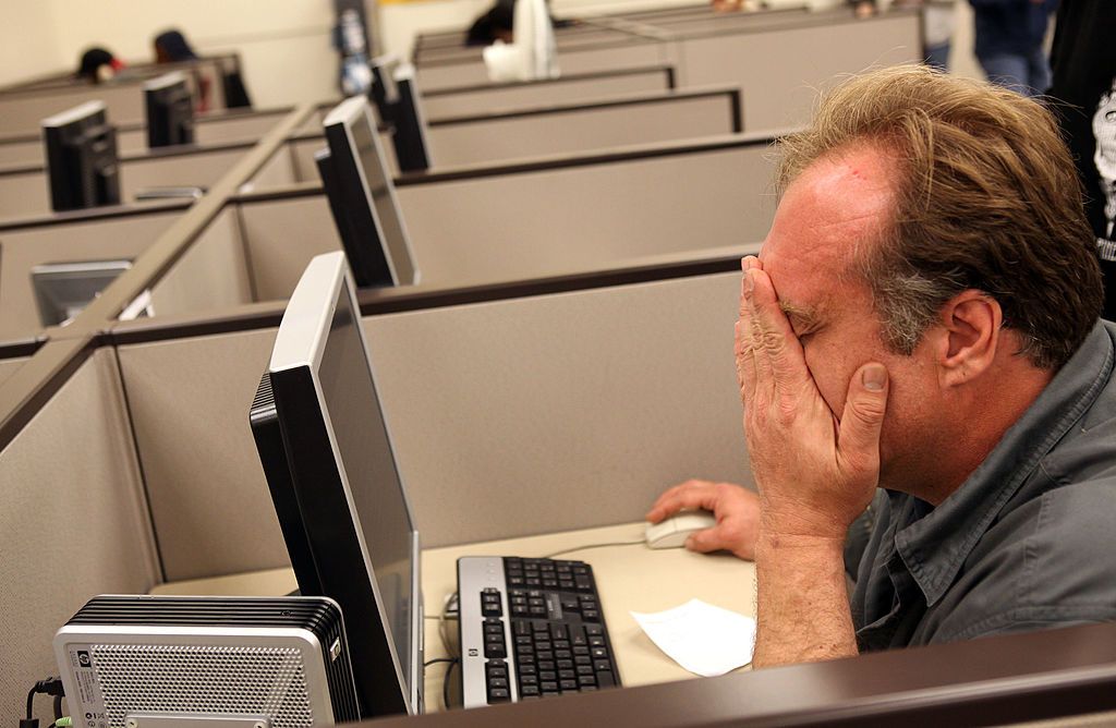 OAKLAND, CA - AUGUST 05: John Heckert wipes his eyes as he uses a computer to fill out paperwork for unemployment insurance at Eastbay Works Oakland One-Stop Career Center August 5, 2010 in Oakland, California. U.S. jobless claims unexpectedly rose by 19,000 new claims for the week ending on July 31. (Photo by Justin Sullivan/Getty Images)