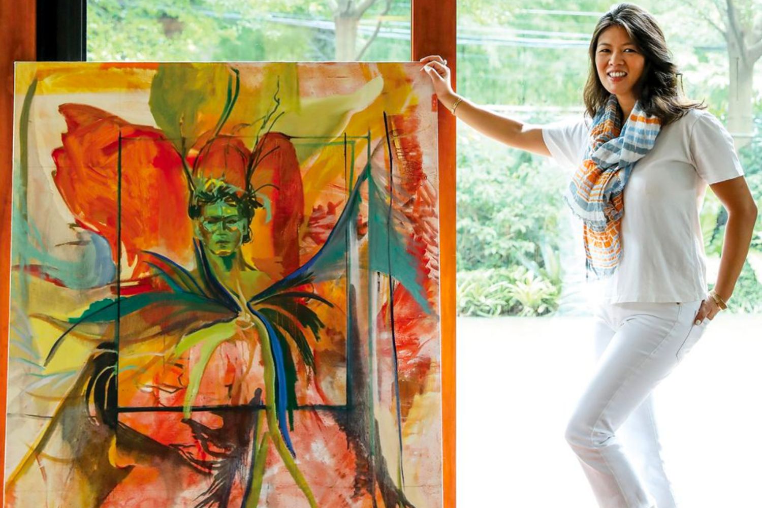 Jana Benitez next to her painting 'Antonio' (2022) which merges her signature styles of poignant figuration and vibrant gestural abstraction