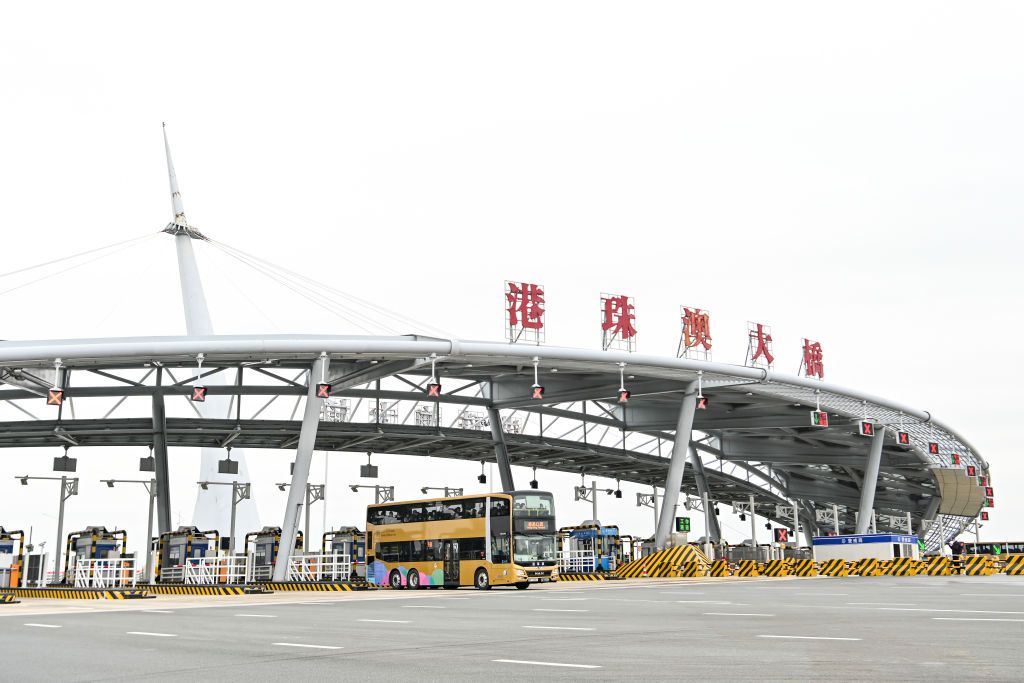 ZHUHAI, CHINA - JANUARY 08: A shuttle bus carrying travellers arrives at Hong Kong-Zhuhai-Macao Bridge Zhuhai Port as China further optimizes its regulations on travel between the mainland and Hong Kong and Macao on January 8, 2023 in Zhuhai, Guangdong Province of China. (Photo by Chen Jimin/China News Service/VCG via Getty Images)