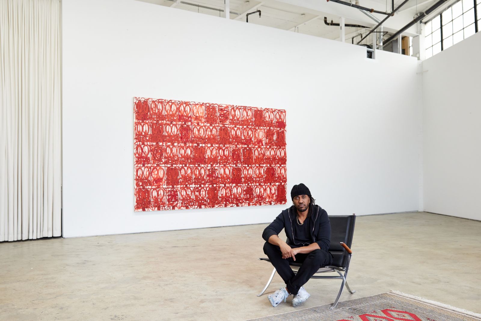 Rashid Johnson in his Brooklyn Studio seated in front a painting from his Anxious Men Series (Photo: Masato Onoda)