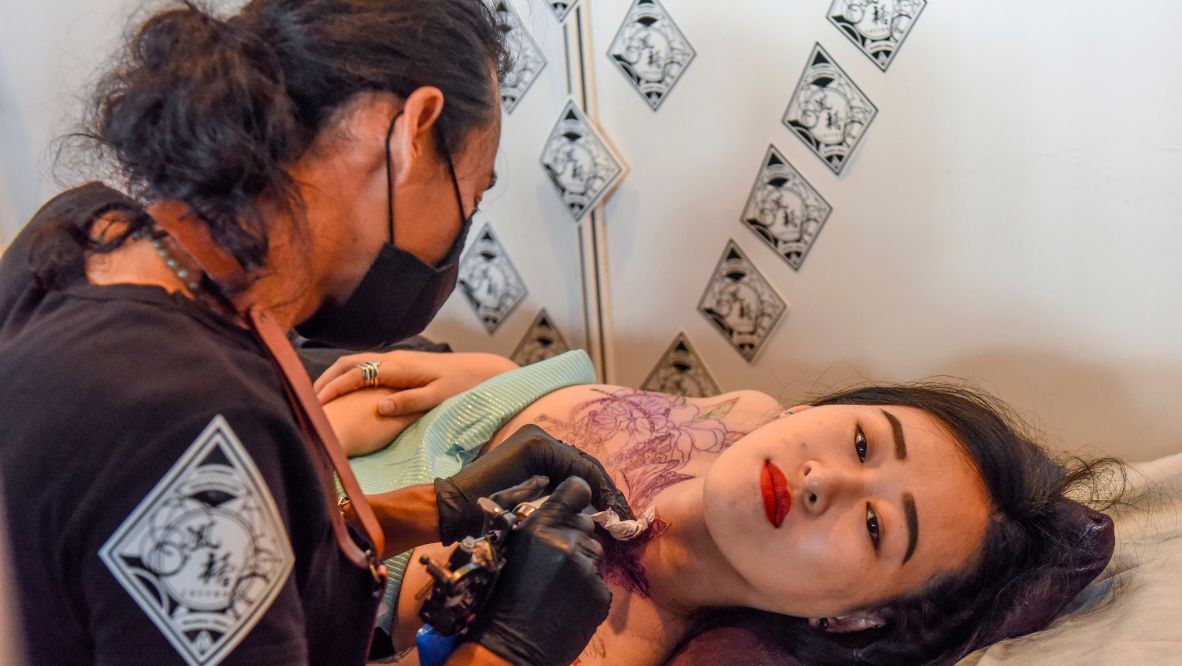 A tattoo artist works on a woman during an international tattoo show on October 24, 2015 in Guangxi Zhuang, China (Photo: Getty Images)