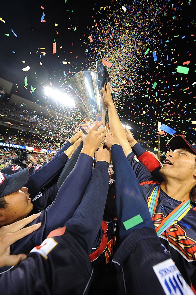 LOS ANGELES - MARCH 23:  Members of team Japan touch the trophy after defeating Korea in the World Baseball Classic final game at Dodger Stadium in Los Angeles, California on March 23, 2009.  Japan defeated Korea 5-3.  (Photo by Rich Pilling/WBCI/MLB via Getty Images)