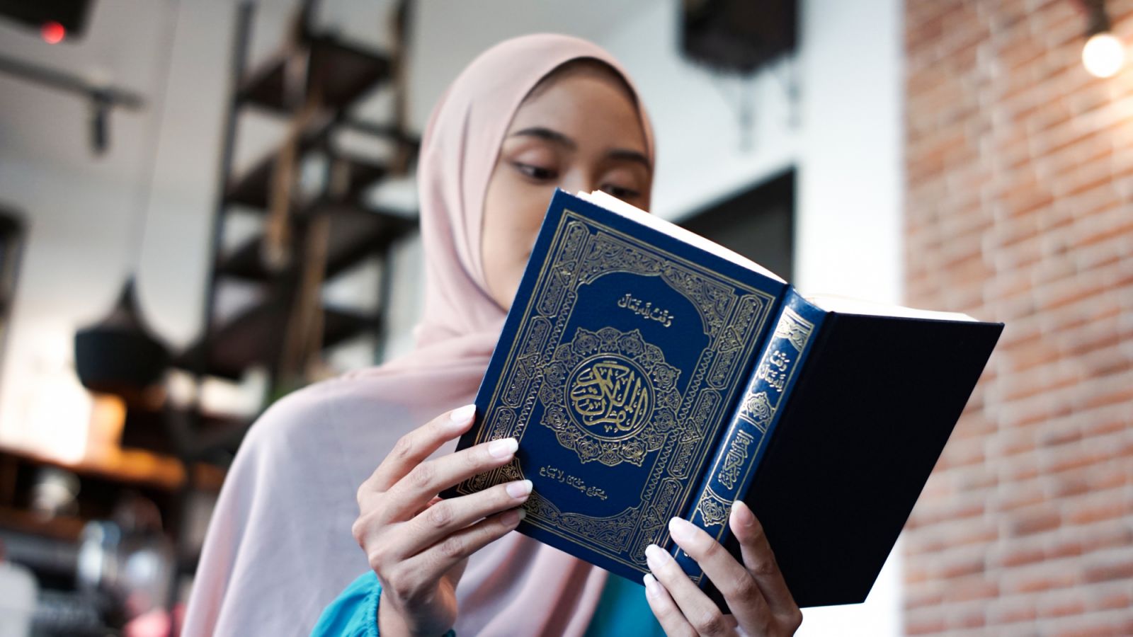 Asian muslim young woman reading the Quran during Ramadan