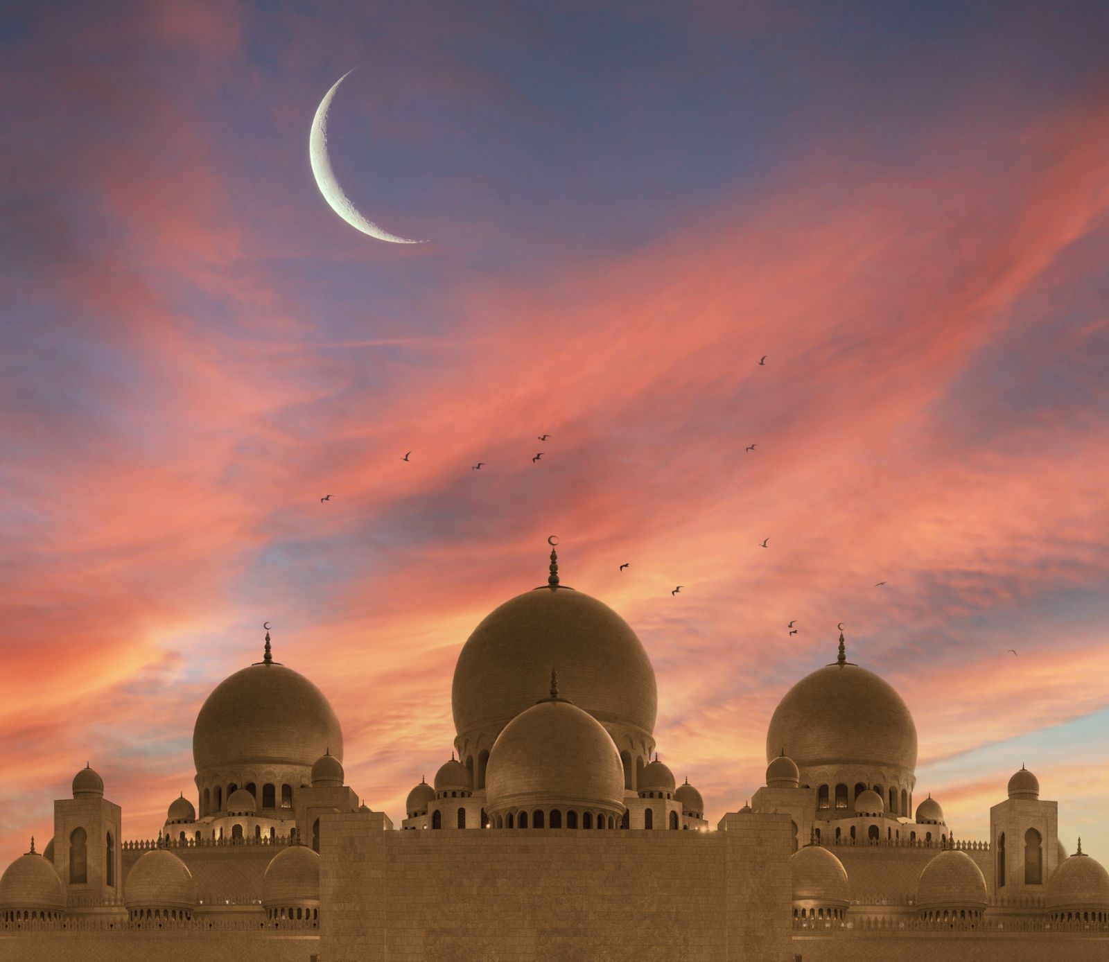 Silhouette of mosque with crescent on sunset sky