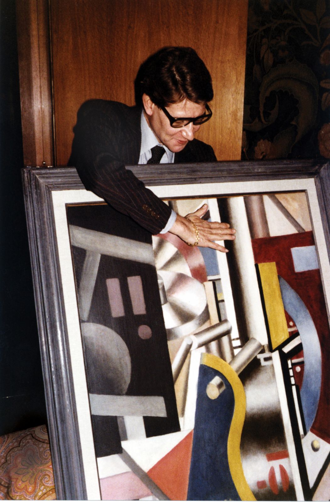 Yves Saint-Laurent at home rue de Solferino in the 80's with the painting 'Composition dans l'usine' by Fernand Leger.  (Photo by Jean-Luc LUYSSEN/Gamma-Rapho via Getty Images)