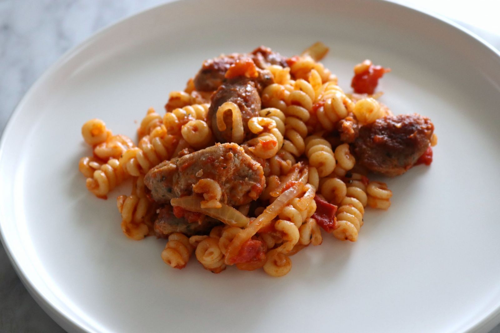 A serving of ChatGPT's pasta with sausage and caramelised onions