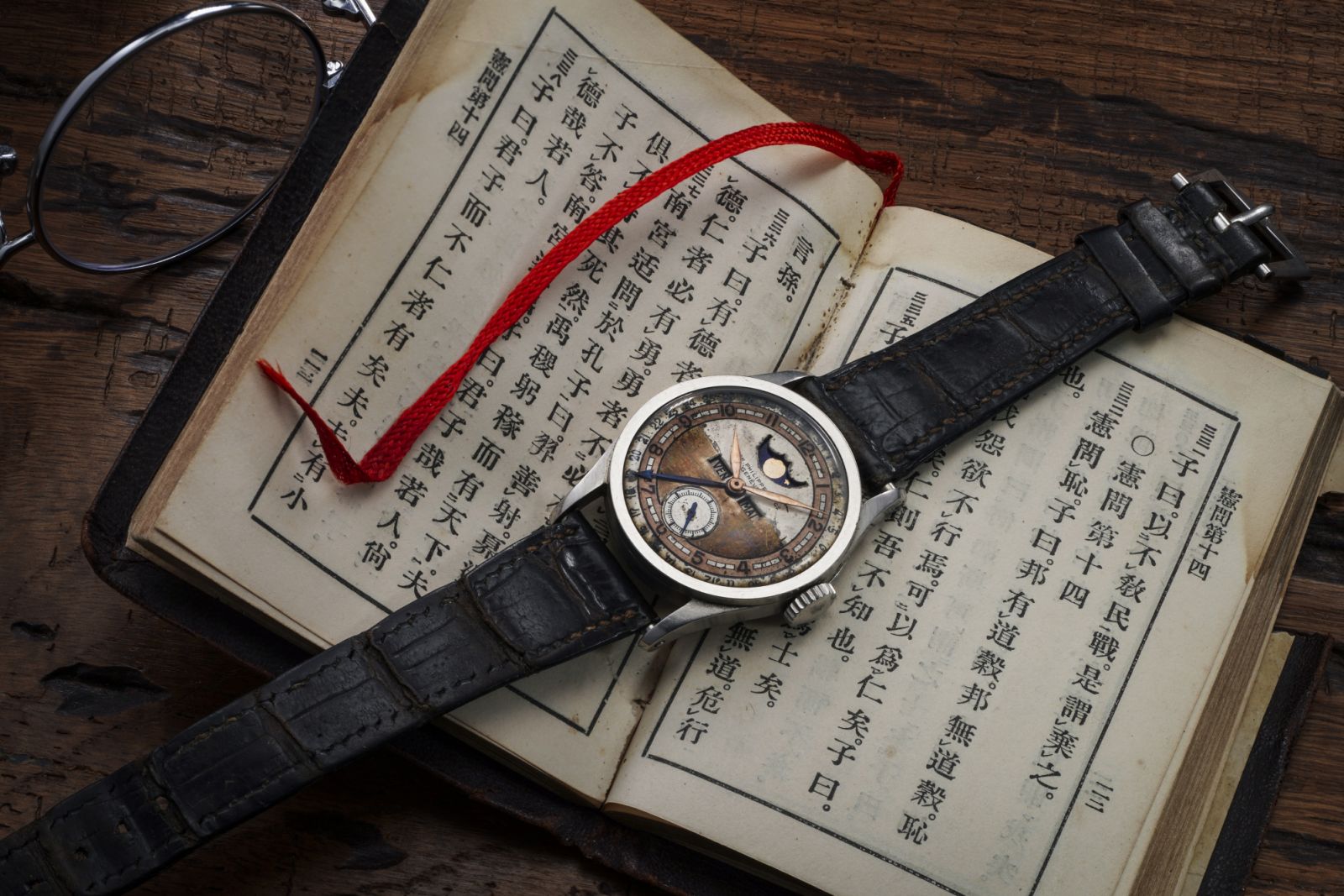 溥儀曾珍藏之百達翡麗型號96 Quantieme Lune,及皮質封面的孔子《論語》
。(Photo by Phillips/Jess Hoffman)