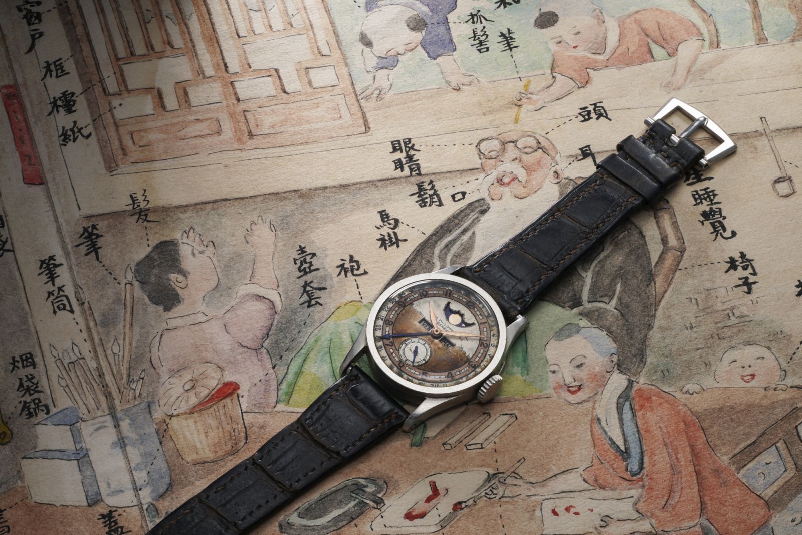 溥儀曾珍藏之百達翡麗型號96 Quantieme Lune,及其內弟郭布羅·潤麒所繪的水墨畫。(Photo by Phillips/Jess Hoffman)