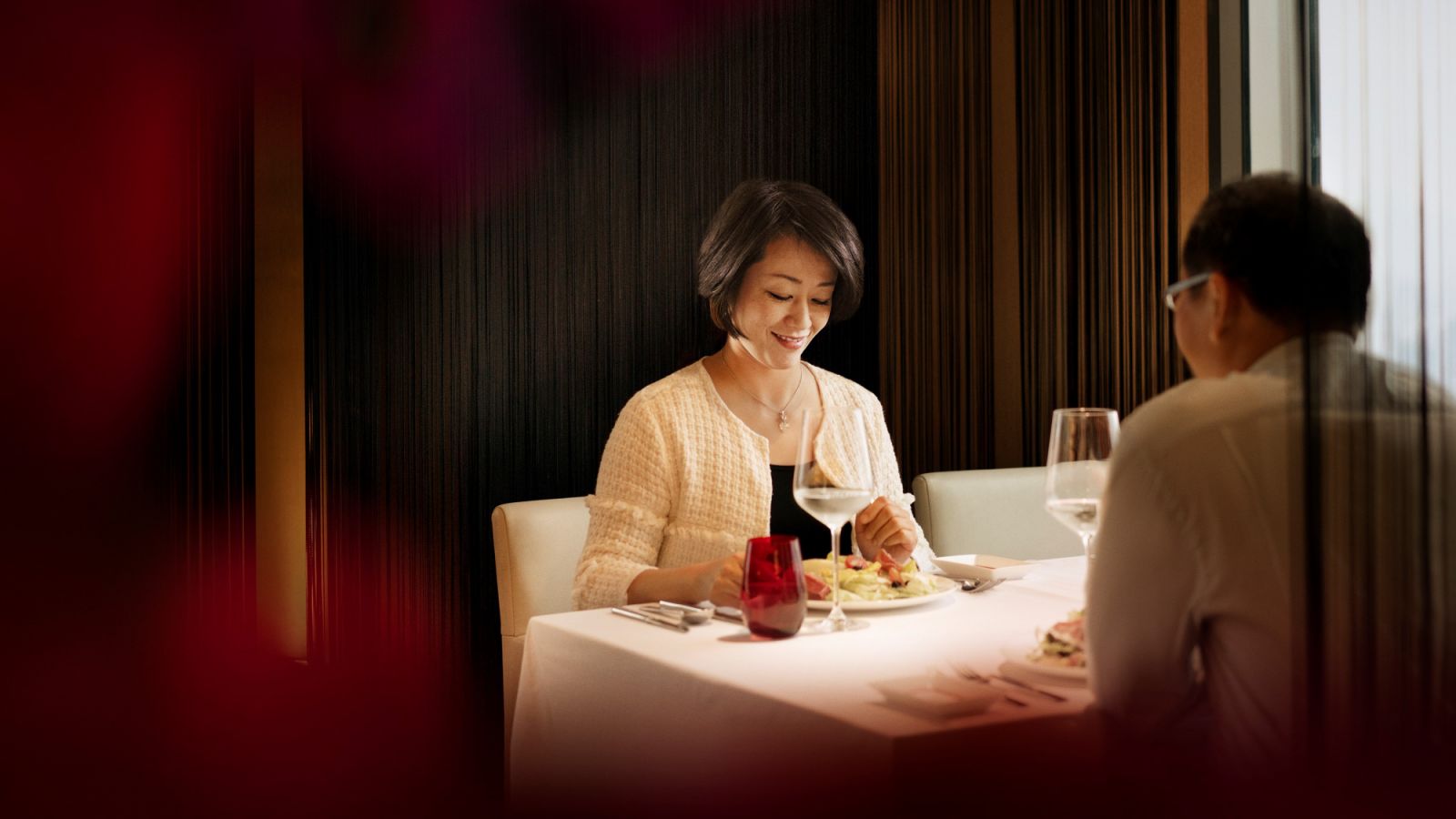 Smiling businesswoman talking with businessman at hotel. Mature female and male professionals are having lunch. They are sitting at restaurant.