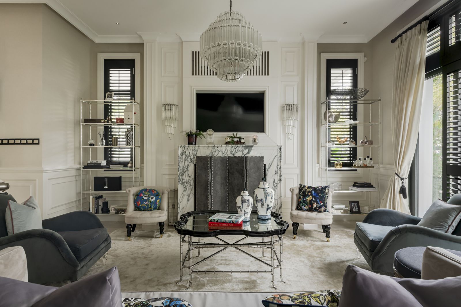 The living room is a tasteful tableau of neutrals punctuated by bright prints