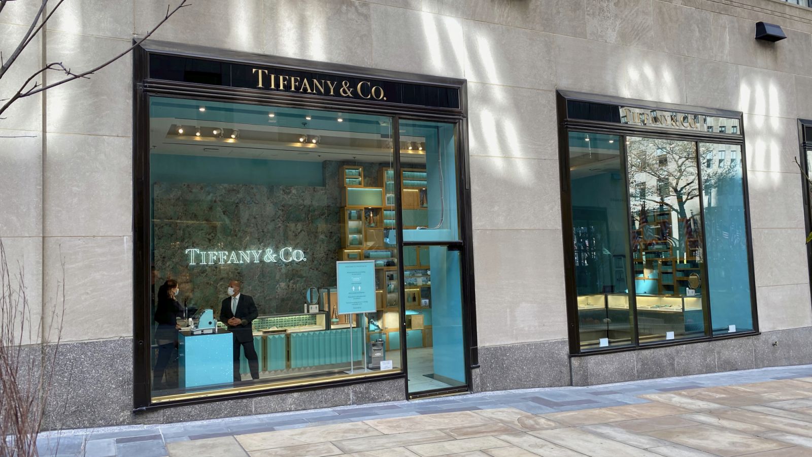 New York, NY, USA - Nov 20, 2020: The storefront entrance on the mall at Rockefeller Center with two employees as seen through the window