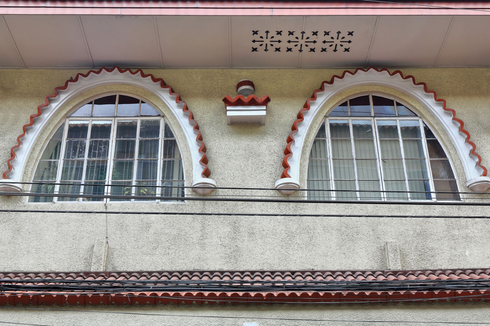 Pair of paned arched windows-Art Deco style decoration on the facade of a commercial office building at the NE corner of General Luna and Real streets. Intramuros-Walled Inner City-Manila-Philippines.