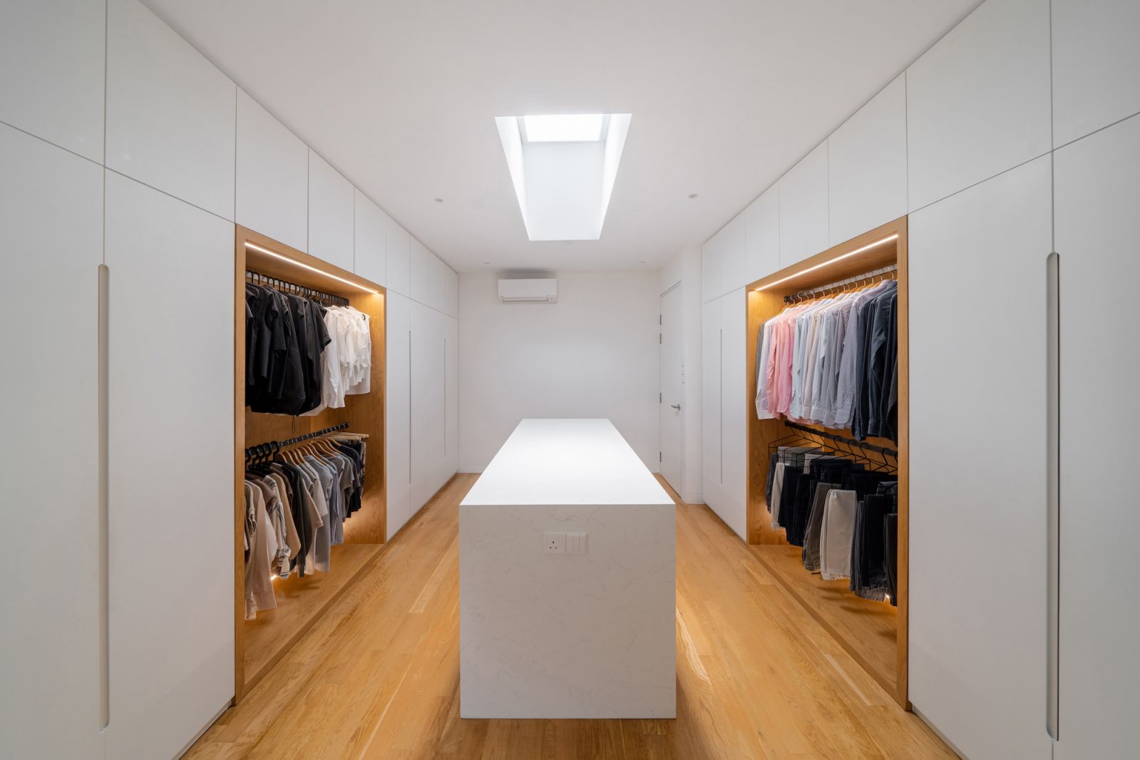 A skylight naturally illuminates the walk in wardrobe