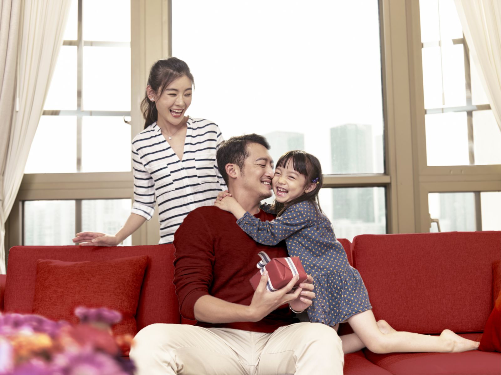 little asian girl hugging father after giving a present